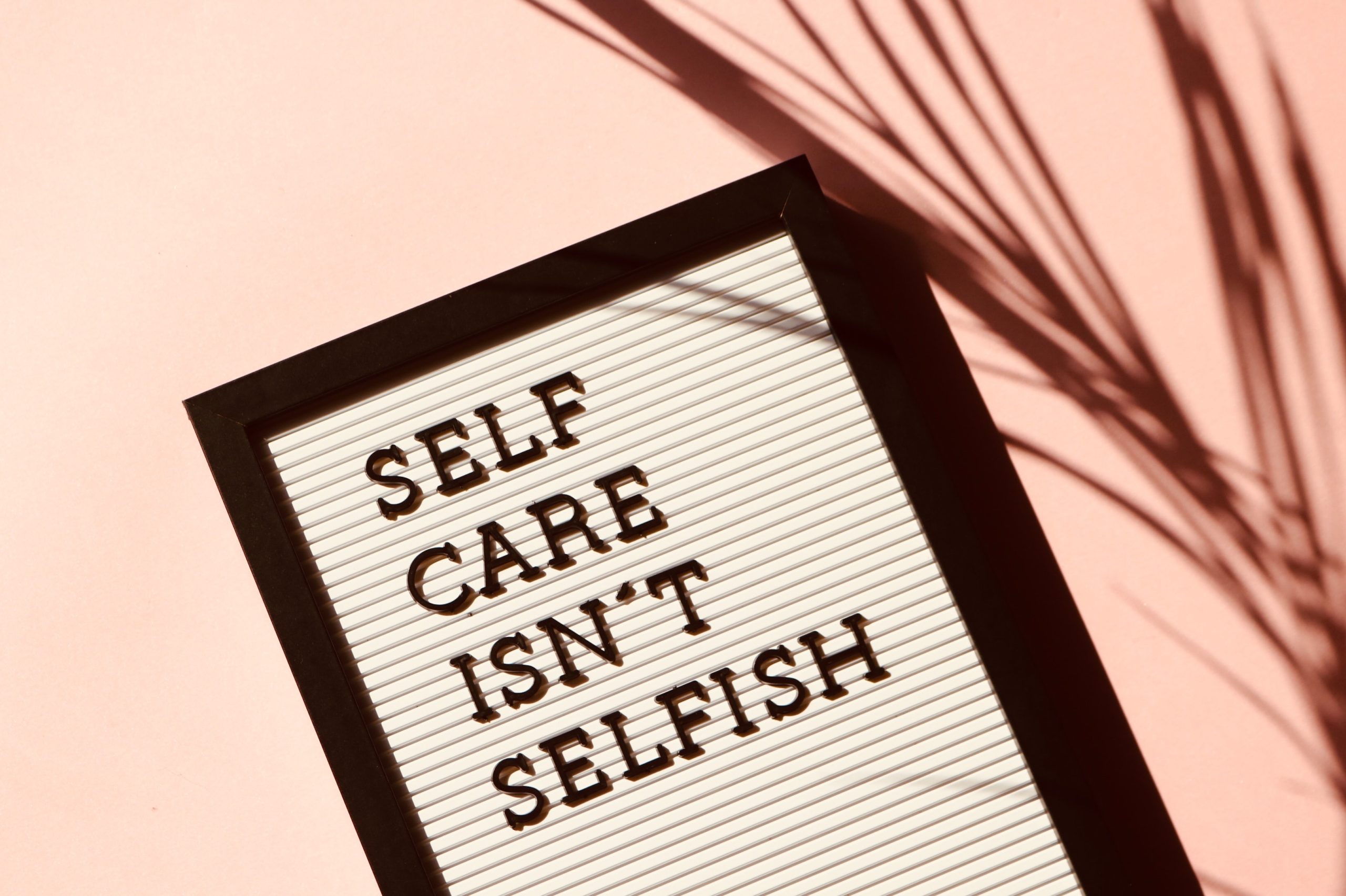 sign on pink background: Self-Care isn't selfish